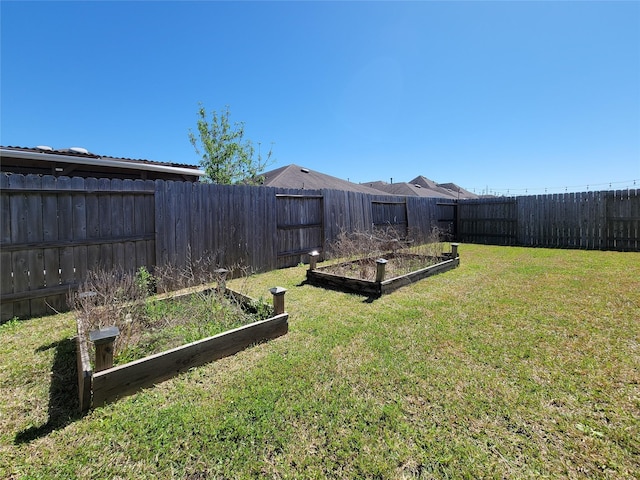 view of yard with a fenced backyard and a vegetable garden