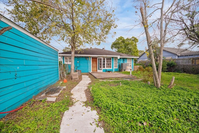 rear view of property with a yard and fence