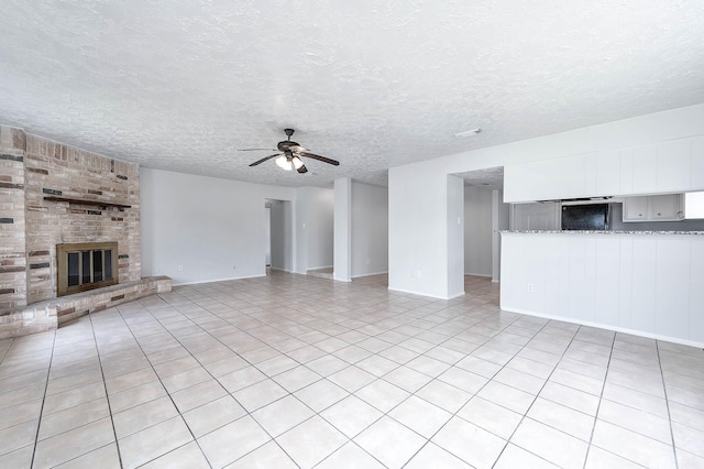 unfurnished living room with a textured ceiling, light tile patterned floors, a fireplace, and a ceiling fan