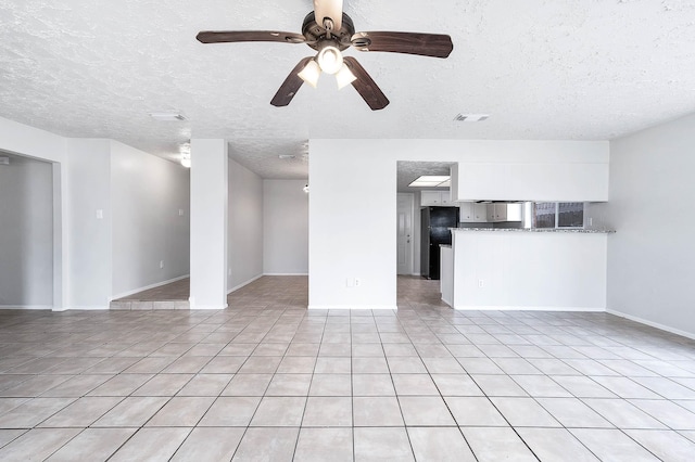 unfurnished living room featuring light tile patterned floors, visible vents, baseboards, ceiling fan, and a textured ceiling