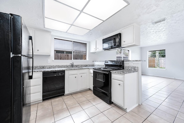 kitchen featuring white cabinetry, visible vents, black appliances, and light tile patterned flooring