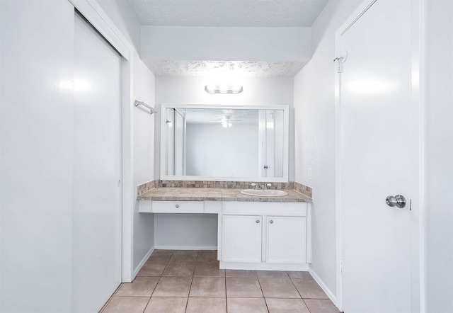 bathroom with a textured ceiling, vanity, and tile patterned floors