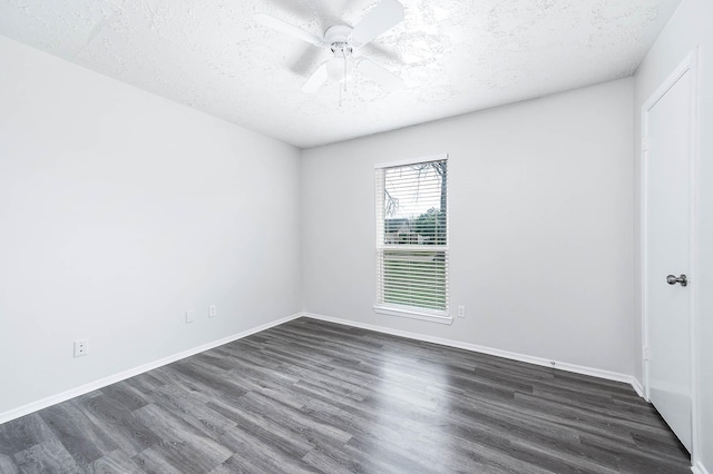 empty room featuring ceiling fan, baseboards, dark wood finished floors, and a textured ceiling