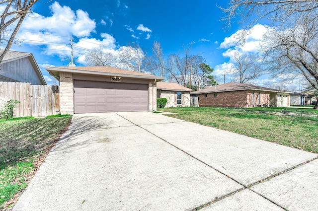 view of front of home featuring driveway, fence, a front lawn, and brick siding