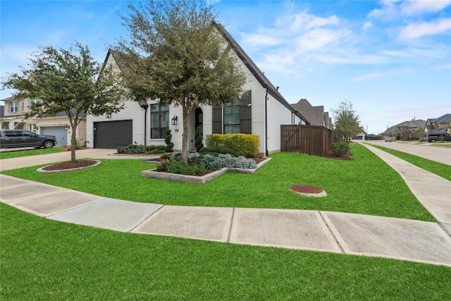 view of front of home featuring driveway, a front lawn, an attached garage, and a residential view