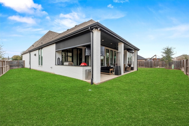 rear view of property with a patio, a lawn, a fenced backyard, and an outdoor living space