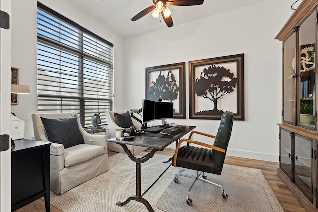 office space featuring ceiling fan, baseboards, and wood finished floors