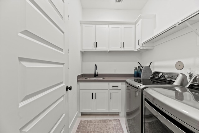 laundry area featuring light tile patterned floors, visible vents, cabinet space, a sink, and washer and dryer