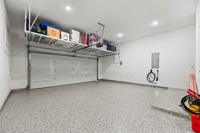 garage with electric panel, baseboards, and recessed lighting