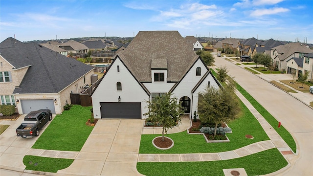 view of front of home featuring a garage, concrete driveway, roof with shingles, a residential view, and a front lawn