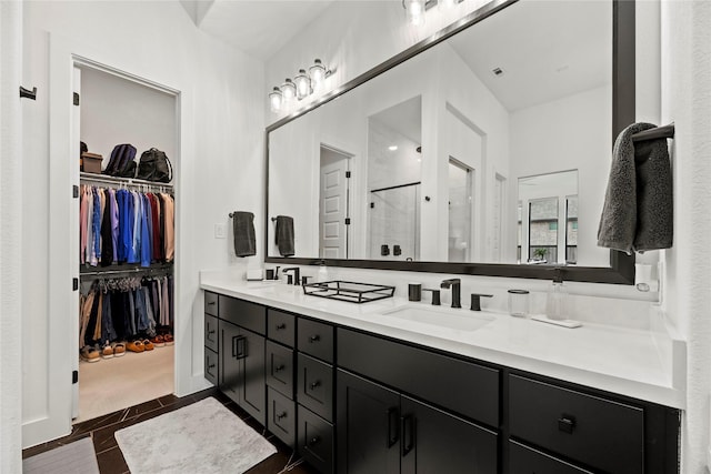 full bath featuring a walk in closet, a sink, a shower stall, and double vanity