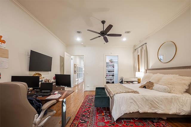 bedroom with light wood finished floors, visible vents, and ornamental molding