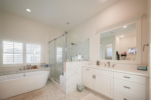 bathroom featuring vanity, a freestanding bath, a healthy amount of sunlight, and a shower stall