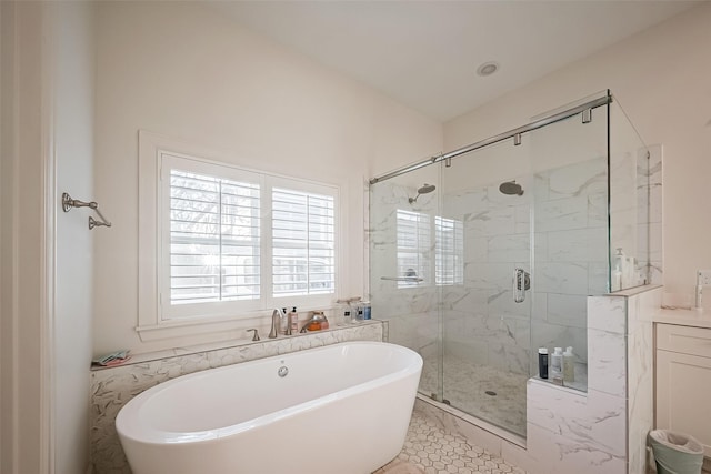 bathroom with a marble finish shower and a freestanding tub