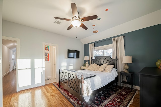 bedroom featuring visible vents, wood finished floors, baseboards, lofted ceiling, and ceiling fan