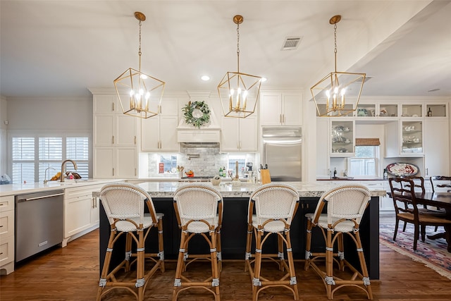 kitchen with stainless steel appliances, backsplash, visible vents, and dark wood-style floors