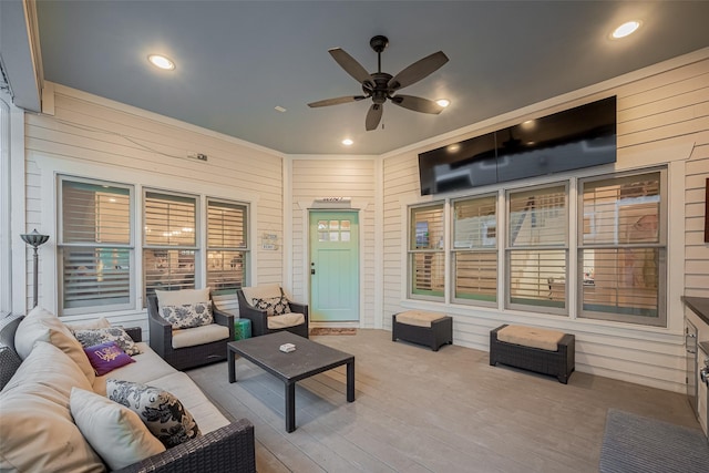 view of patio featuring a deck, an outdoor living space, and a ceiling fan