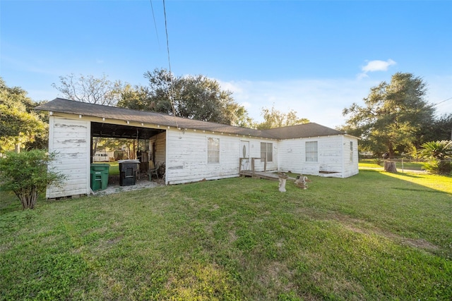 rear view of property featuring an outdoor structure and a yard