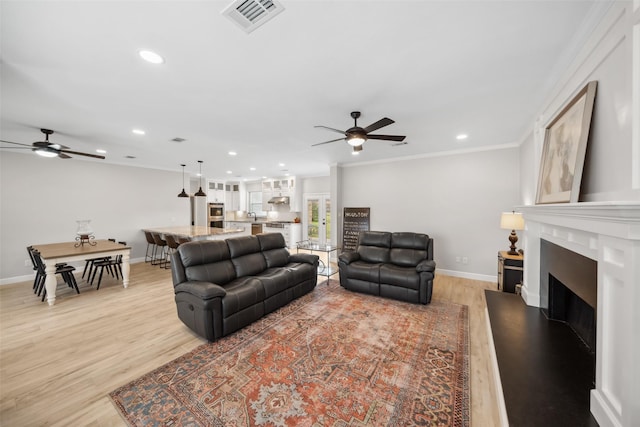 living room featuring recessed lighting, light wood-type flooring, visible vents, and baseboards