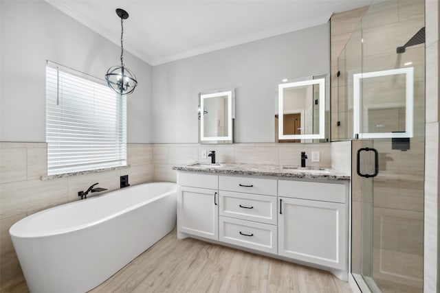 full bathroom featuring double vanity, a freestanding tub, a sink, and a shower stall