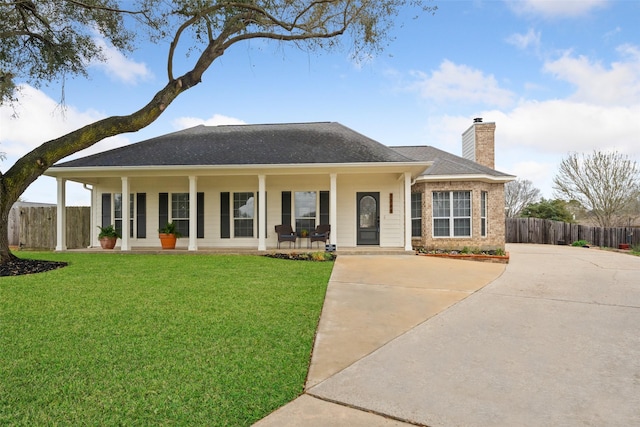 view of front of property with a chimney, covered porch, a front yard, fence, and driveway