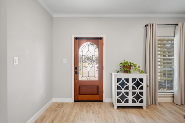 foyer entrance featuring crown molding, baseboards, and wood finished floors