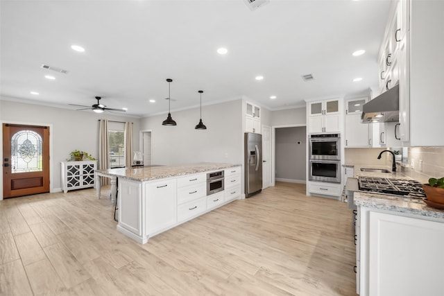 kitchen with stainless steel appliances, visible vents, backsplash, a sink, and under cabinet range hood