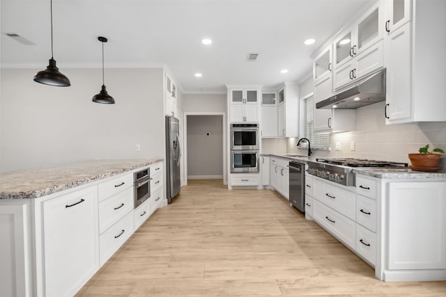 kitchen with under cabinet range hood, stainless steel appliances, a sink, visible vents, and light stone countertops