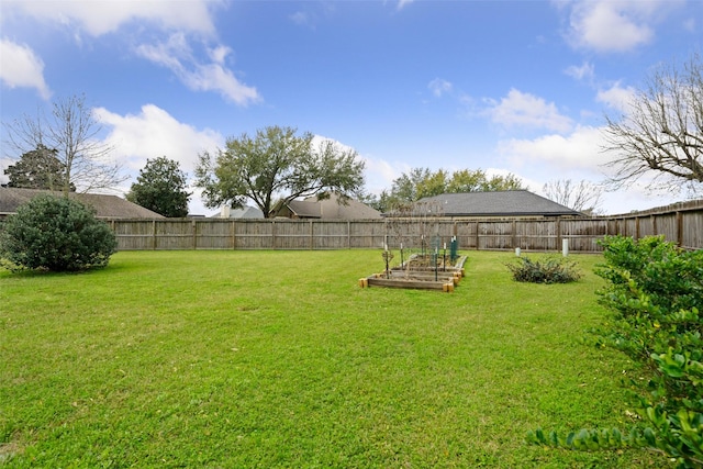 view of yard featuring a fenced backyard and a vegetable garden