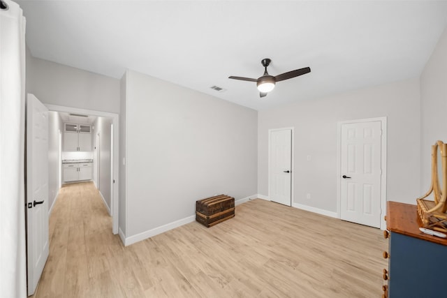 unfurnished bedroom with light wood finished floors, attic access, visible vents, and baseboards