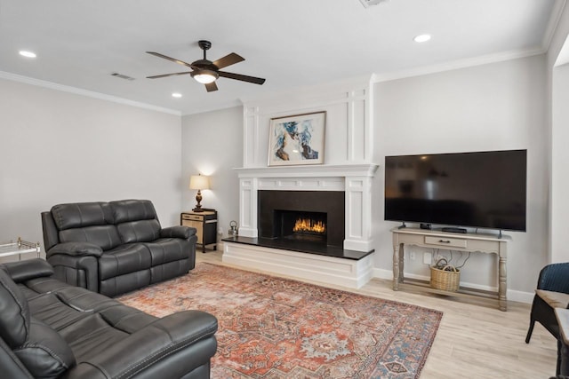 living room with recessed lighting, visible vents, baseboards, ornamental molding, and light wood-type flooring