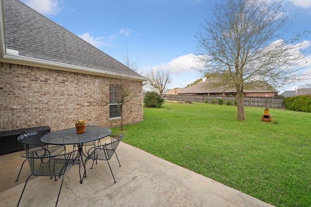 view of yard with a patio, outdoor dining area, and fence