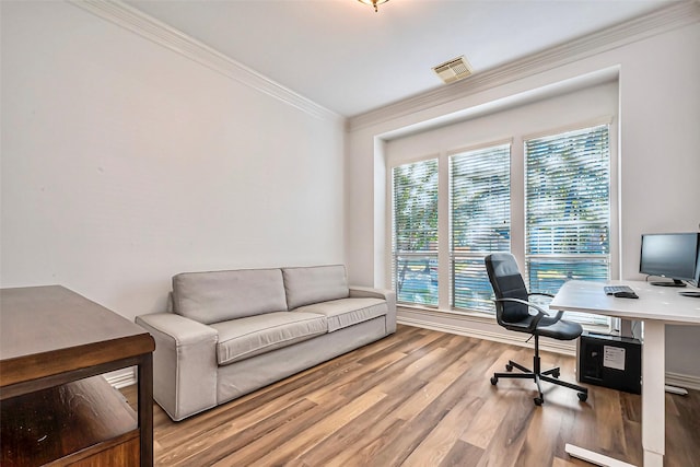 office space featuring wood finished floors, visible vents, and crown molding