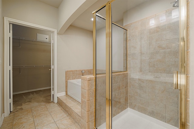 bathroom with a shower stall, a spacious closet, and a bath