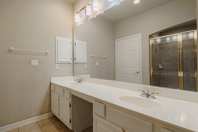 bathroom with double vanity, a stall shower, baseboards, tile patterned flooring, and a sink