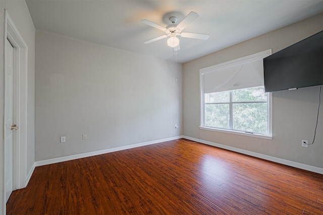 empty room featuring wood finished floors, a ceiling fan, and baseboards