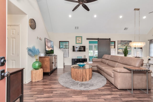 living room with high vaulted ceiling, a barn door, recessed lighting, ceiling fan with notable chandelier, and wood finished floors