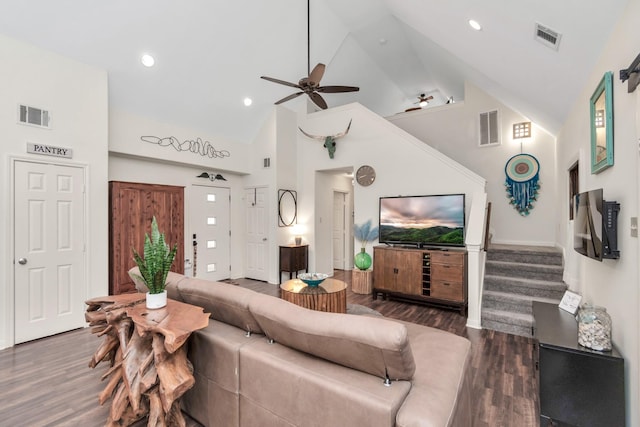 living area featuring dark wood-style floors, visible vents, and stairway