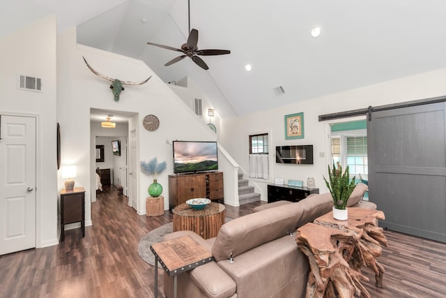 living room with stairs, a barn door, wood finished floors, and visible vents