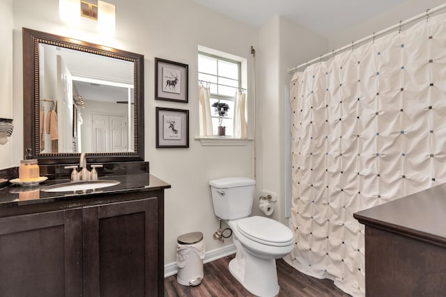 full bathroom with baseboards, toilet, wood finished floors, curtained shower, and vanity