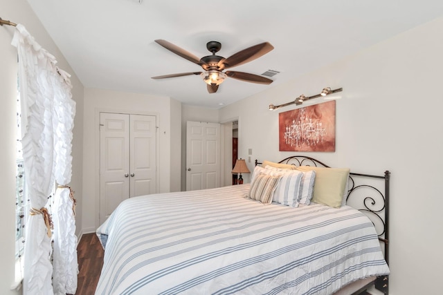 bedroom featuring a ceiling fan, a closet, visible vents, and wood finished floors