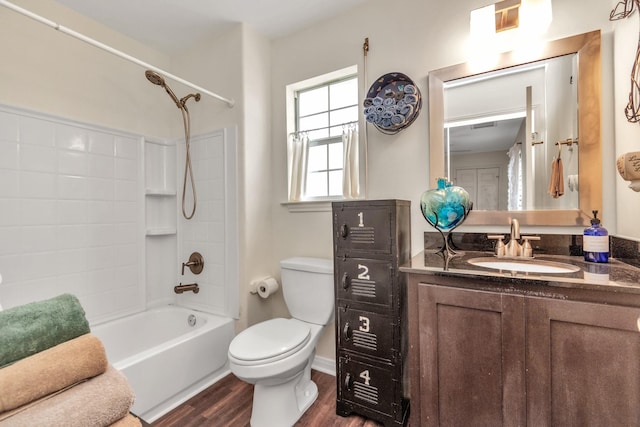 full bath with washtub / shower combination, vanity, wood finished floors, and toilet