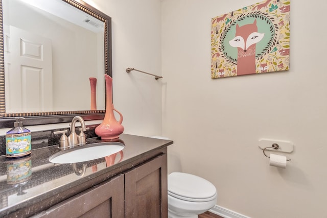 bathroom featuring baseboards, visible vents, vanity, and toilet