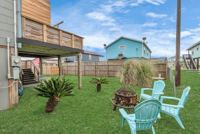 view of yard with an outdoor fire pit, stairway, fence private yard, and a wooden deck