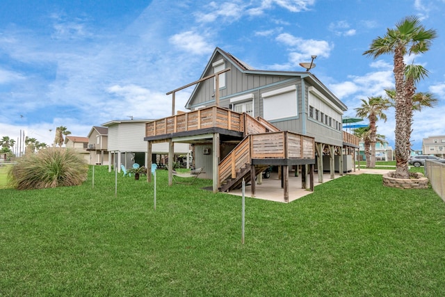 back of property featuring board and batten siding, a yard, a patio, and stairway