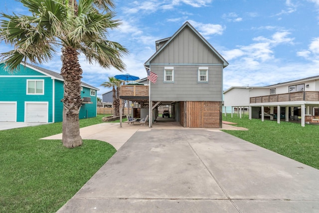 coastal inspired home with board and batten siding, a carport, driveway, a front lawn, and stairs