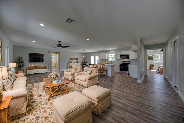 living room with dark wood-type flooring, recessed lighting, visible vents, and a ceiling fan