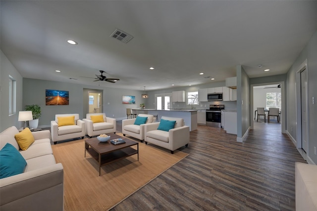 living room with recessed lighting, dark wood-style flooring, visible vents, and a healthy amount of sunlight