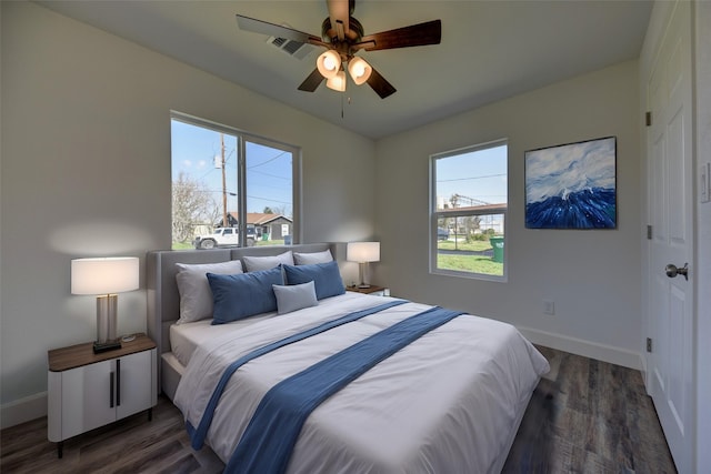 bedroom with wood finished floors, visible vents, and multiple windows