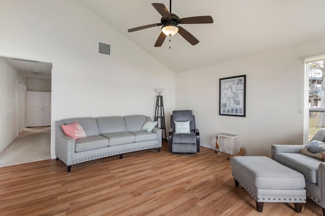 living area with light wood-style floors, ceiling fan, visible vents, and high vaulted ceiling